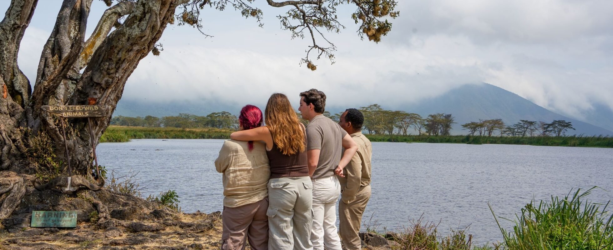 Vier mensen die gearmd naar de natuur kijken