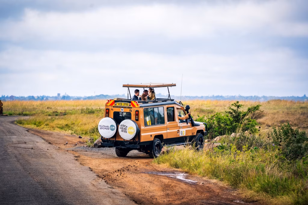 Een safarijeep van Afrika Safari met passagiers die door het open dak naar de Afrikaanse bush kijken